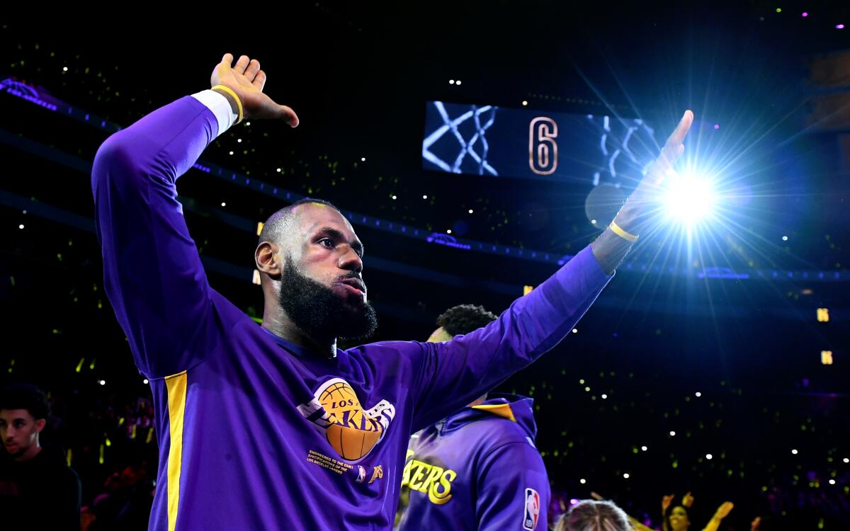 Lakers forward LeBron James prepares to high-five a teammate as he's introduced before the start of a game.