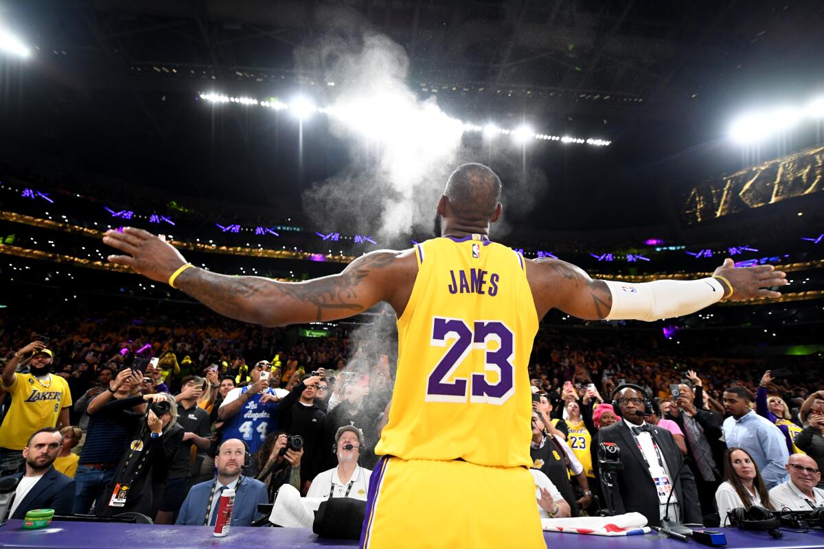 Lakers star LeBron James tosses powder above the scorer's table before a game against the Suns.