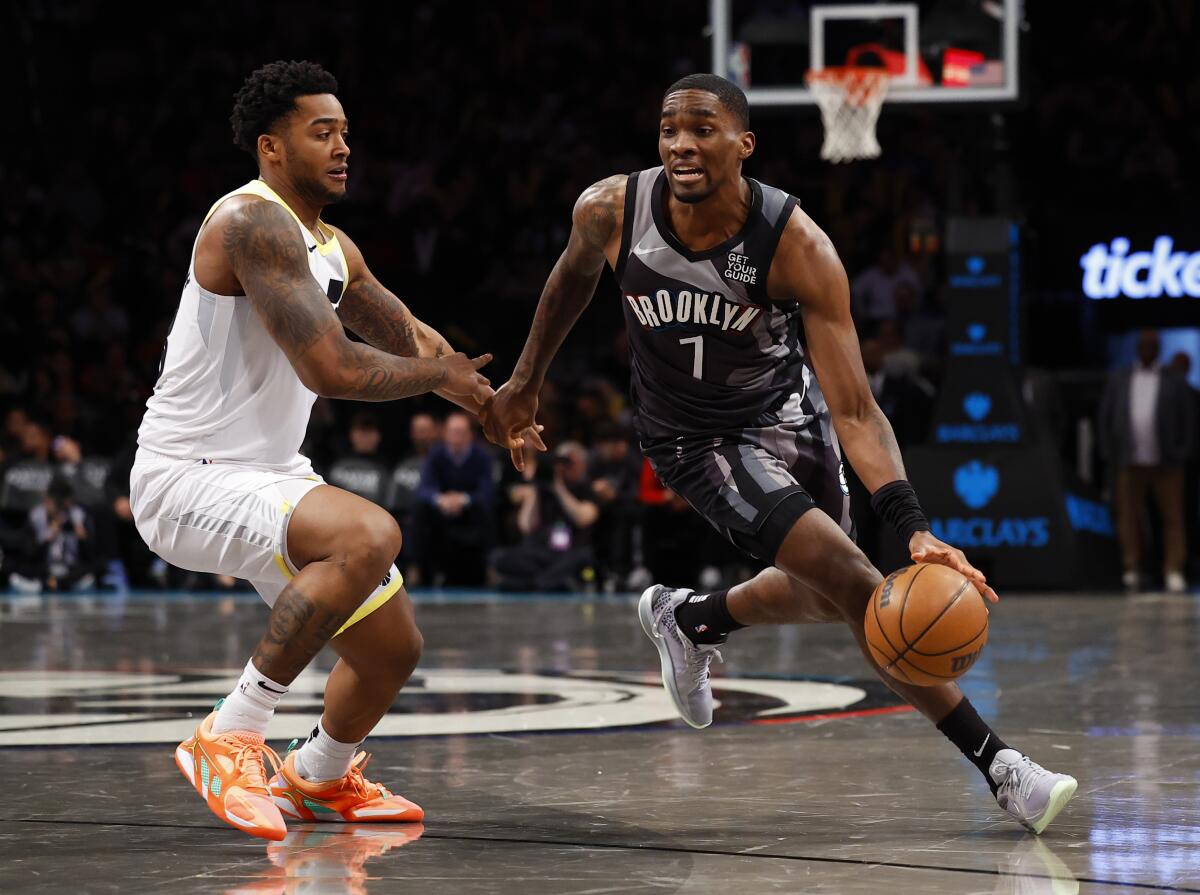 Nets guard Shake Milton, right, drives to the basket against Jazz forward Brice Sensabaugh.