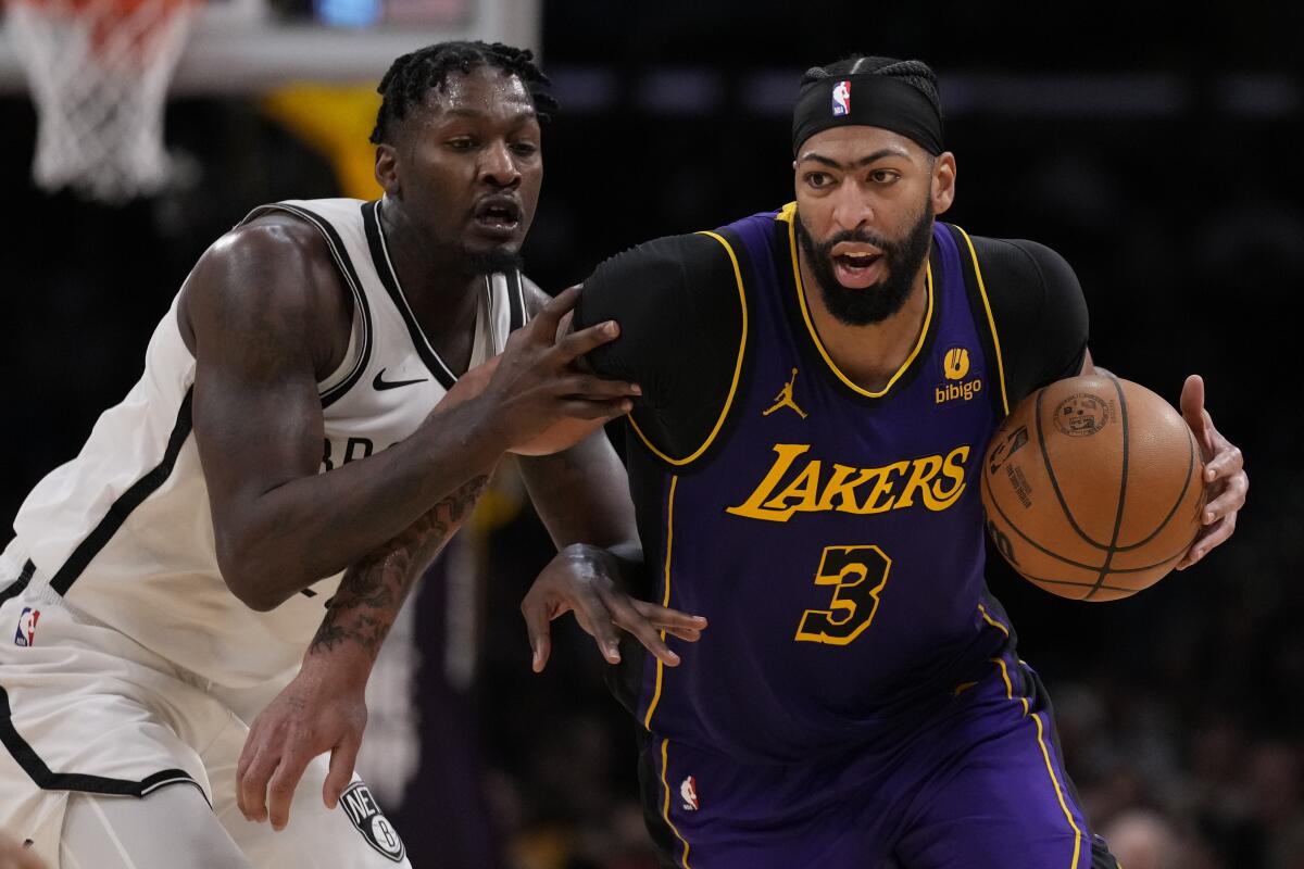 Brooklyn Nets forward Dorian Finney-Smith, left, defends against Lakers forward Anthony Davis during a game in January 2024.