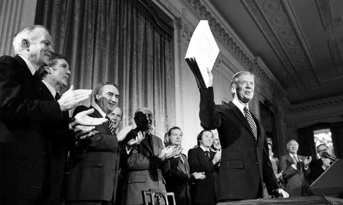 President Jimmy Carter holds up the Alaska National Interest Lands Conservation Act after signing the bill into law in 1980.