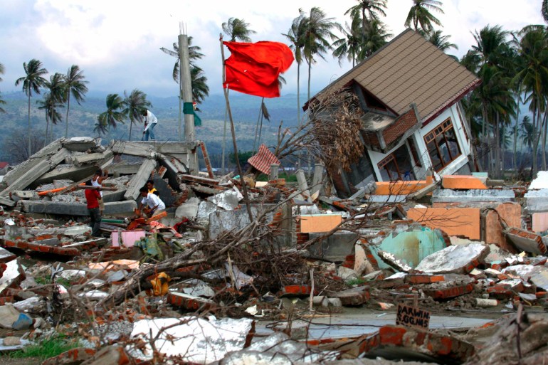 Achenese men walk amid the debris of their devastated houses following the 2004 tsunami at a housing complex in Kajhu on the outskirts of Banda Aceh, in this April 3, 2005 file photo. A massive undersea earthquake is long overdue beneath the Mentawai islands in Indonesia and could trigger another deadly tsunami, say scientists mapping one of the world's most quake-prone zones. Unlike the 2004 Indian Ocean tsunami, which killed around 226,000 people, this tsunami is expected to be smaller but may be very deadly as it would hit Sumatra's densely populated coast. To match feature TSUNAMI-ANNIVERSARY/RISK REUTERS/Steve Crisp/Files (INDONESIA - Tags: ANNIVERSARY DISASTER)