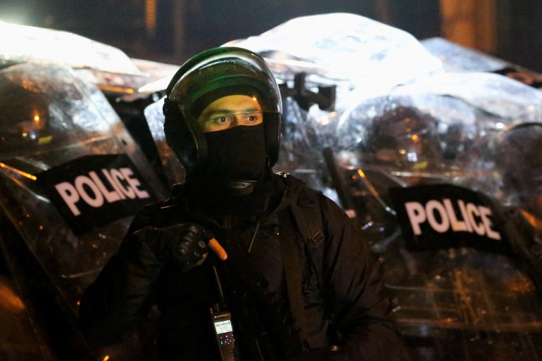 Police officers in riot gear operate as supporters of Georgia's opposition parties hold a rally to protest against the government's decision to suspend talks on joining the European Union, in Tbilisi, Georgia