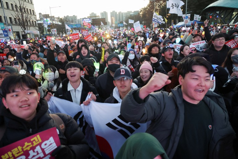 People celebrate after South Korean parliament passed a second impeachment motion against President Yoon Suk Yeol over his martial law decree following a vote, during a rally calling for the impeachment of President Yoon Suk Yeol, who declared martial law, which was reversed hours later, in front of the National Assembly in Seoul, South Korea, December 14, 2024. REUTERS/Kim Hong-Ji