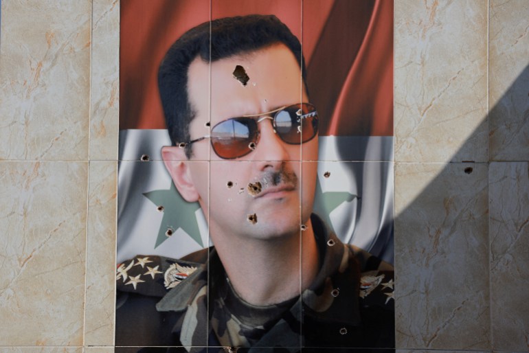 An image of Syria's Bashar al-Assad is damaged by bullet holes