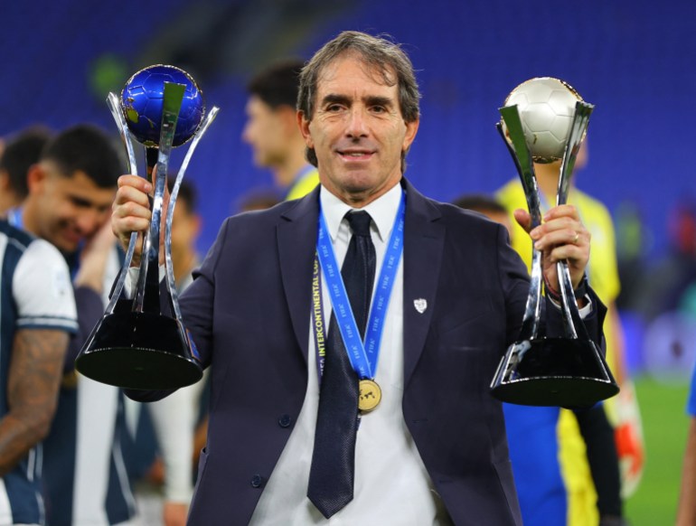 Soccer Football - Intercontinental Cup - Challenger Cup - Pachuca v Al Ahly - Stadium 974, Doha, Qatar - December 14, 2024 Pachuca coach Guillermo Almada lifts the trophies after winning the Challenger Cup REUTERS/Ibraheem Al Omari