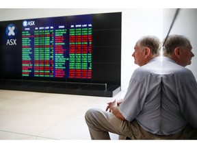 A man looks at an electronic board displaying stock information at the Australian Securities Exchange, operated by ASX Ltd., in Sydney, Australia, on Tuesday, Feb. 6, 2018. Global equity markets are in retreat after Wall Street losses that began in the final session of last week worsened on Monday, with the Dow Jones Industrial Average posting its biggest intraday point drop in history. Photgrapher: Brendon Thorne/Bloomberg