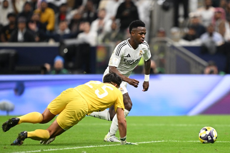 Pachuca's Mexican goalkeeper #25 Carlos Moreno dives after the ball in a challenge against Real Madrid's Brazilian forward #7 Vinicius Junior during the 2024 FIFA Intercontinental Cup final football match between Spain's Real Madrid and Mexico's Pachuca at the Lusail Stadium in Doha on December 18, 2024. (Photo by Mahmud HAMS / AFP)