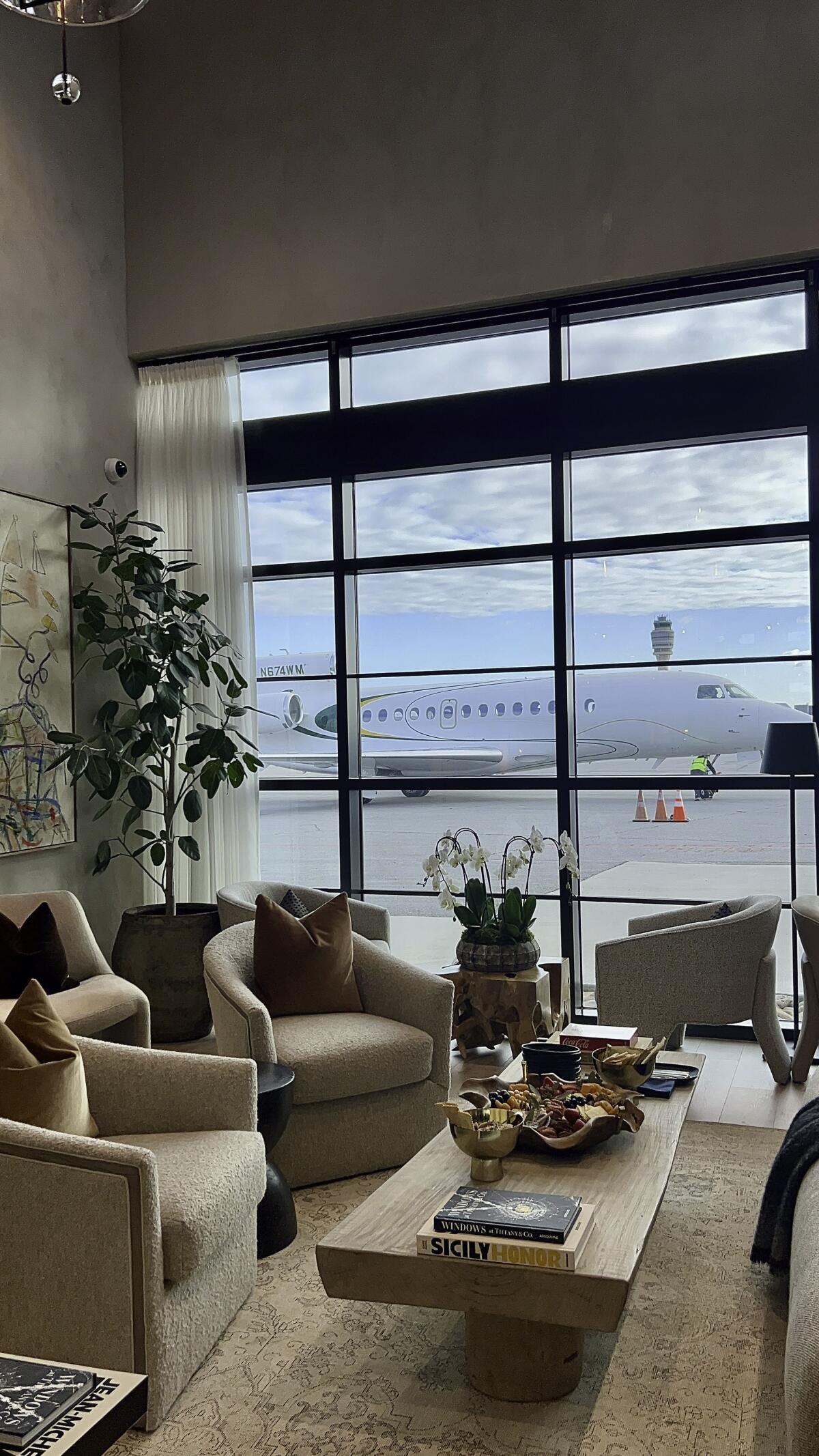 Lounge chairs by a window with an airplane view at PS Private Suite.