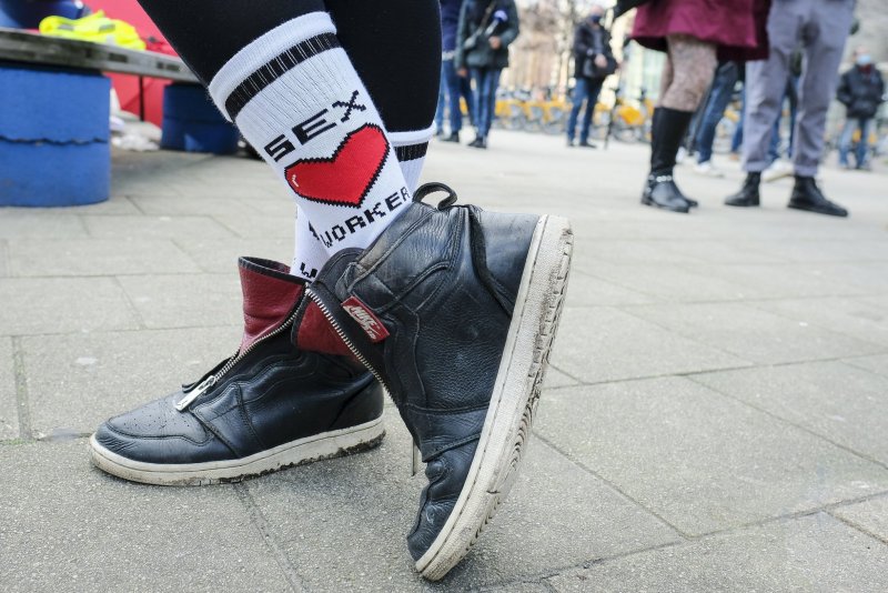 A woman shows her socks with a sign 'sex worker' during a protest organized by the Belgian Union of Sex Workers against the closure of sex work activities in Brussels amid the COVID-19 pandemic. File photo by Julien Warnand/EPA-EFE