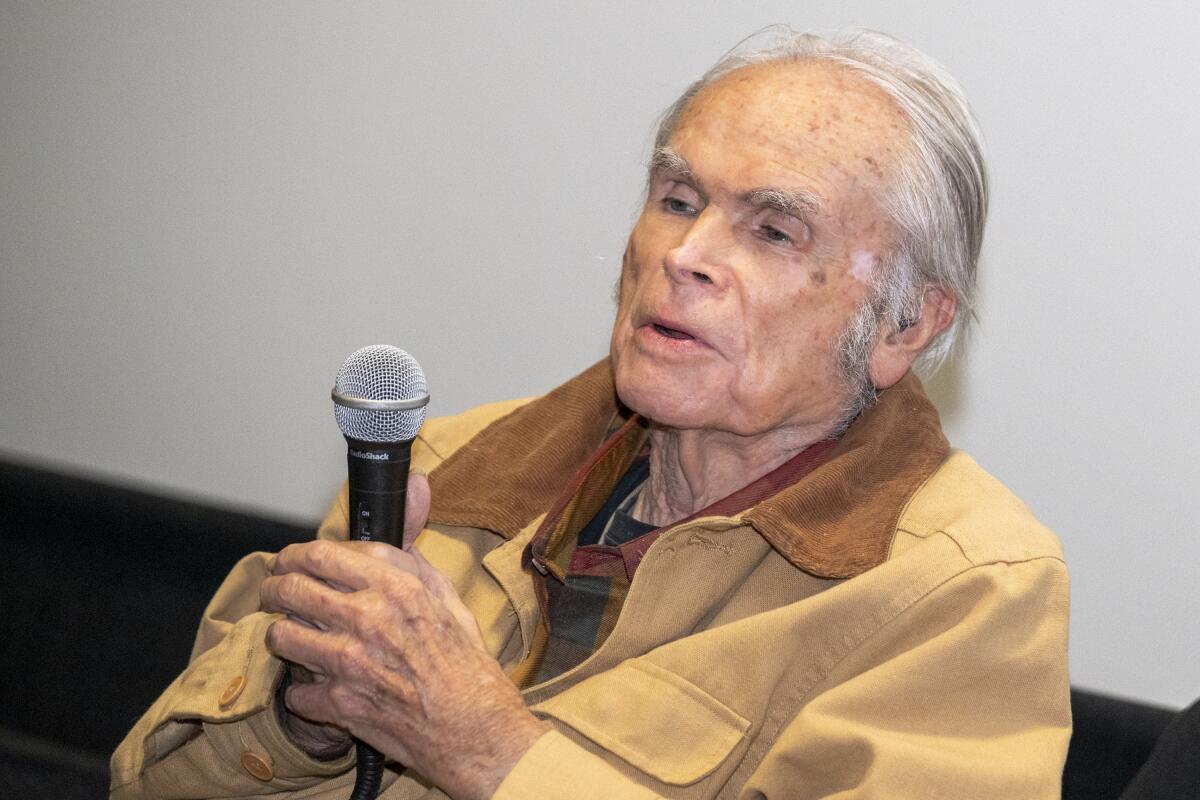 A man with a microphone does a post-screening Q&A.