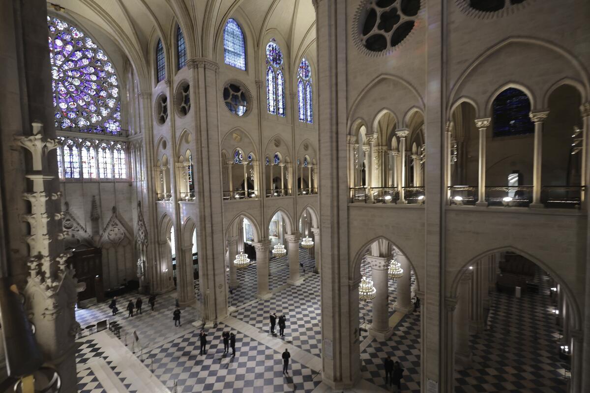 People stroll inside the restored Notre Dame Cathedral during French officials' visit.