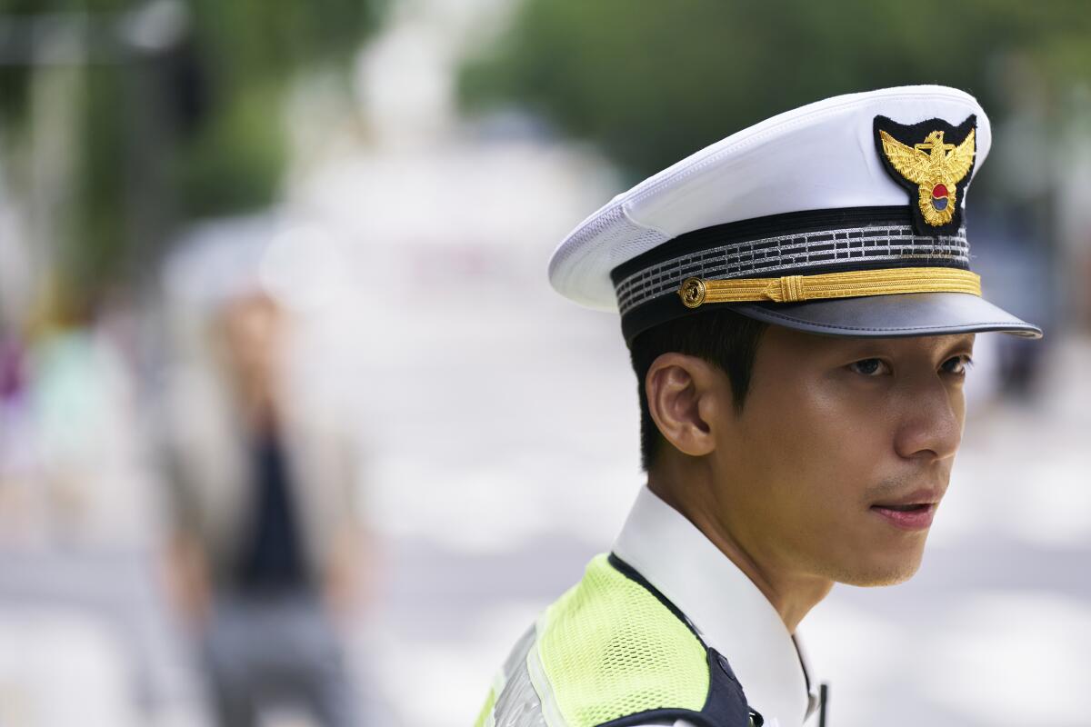 A profile shot of a man in a white police uniform and hat, seen from the shoulders up.