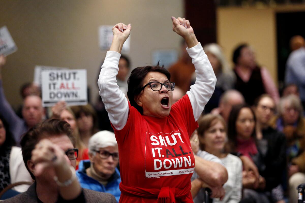 A woman protests at a public meeting.