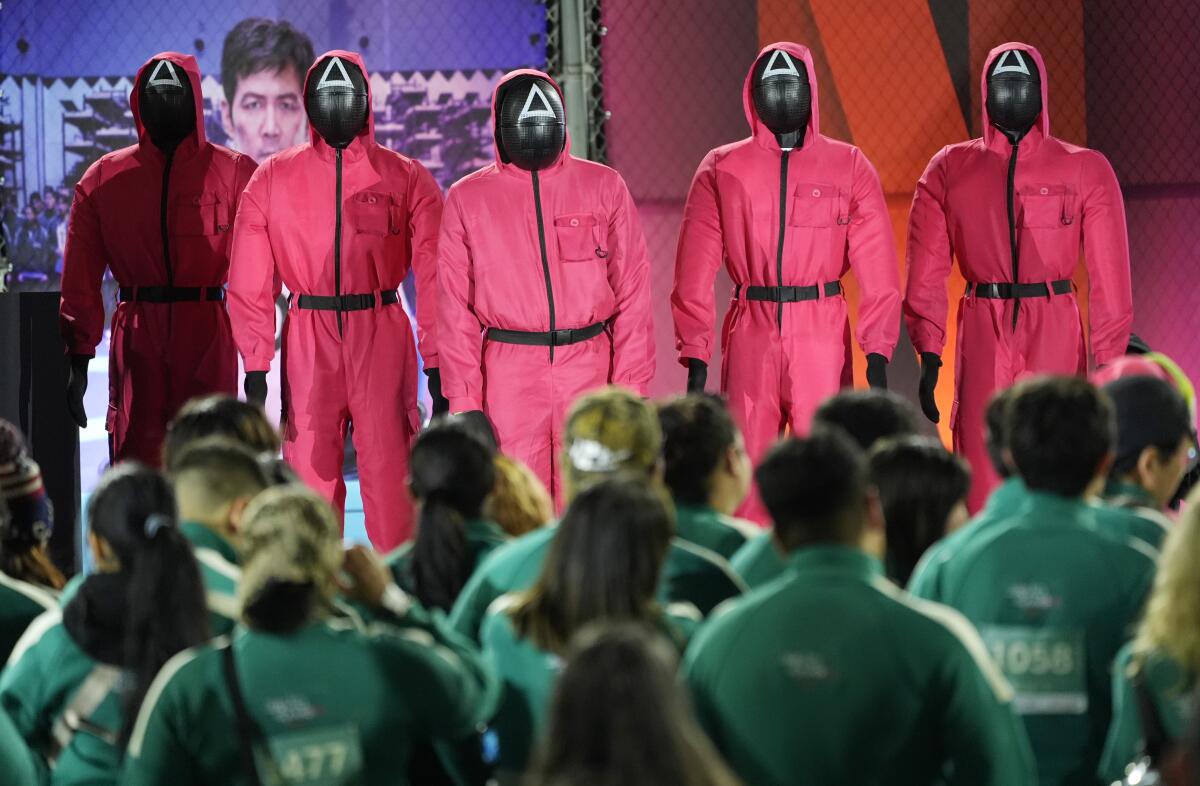 Costumed "Squid Game" guards watch over the crowd at the premiere of the second season of the Netflix series.