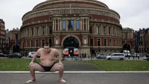 Getty Images Sumo wrestler wrestler Kitanowaka Daisuke performs a sumo squat outside the Royal Albert Hall.