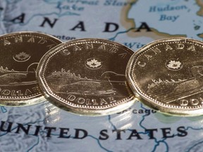 Canadian dollar coins, or loonies, are displayed on a map of North America in Montreal in a Thursday, Jan. 9, 2014, photo illustration.