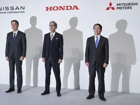 Nissan Chief Executive Makoto Uchida, left, Honda Chief Executive Toshihiro Mibe, center, and Takao Kato, CEO of Mitsubishi Motors, right, pose for photographers during a joint news conference in Tokyo, Japan, Monday, Dec. 23, 2024.