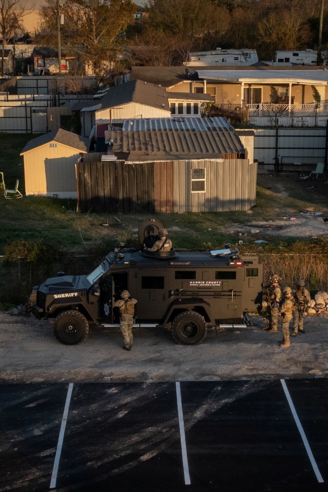 A drone view shows the Federal Bureau of Investigation (FBI) and Harris County law enforcement officials as they surround a residence in an armored vehicle