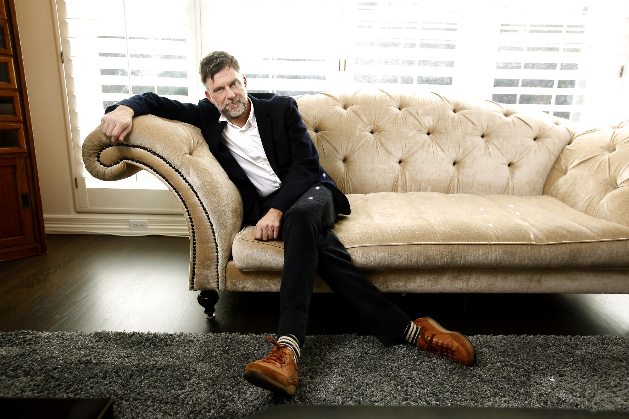 A director poses on a couch.