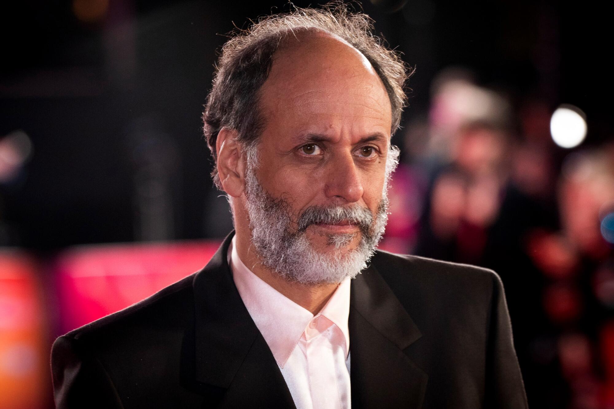 A director is photographed on a carpet.