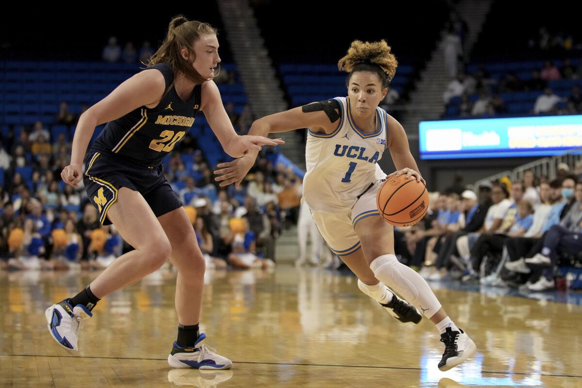 UCLA guard Kiki Rice dribbles around Michigan forward Alyssa Crockett.