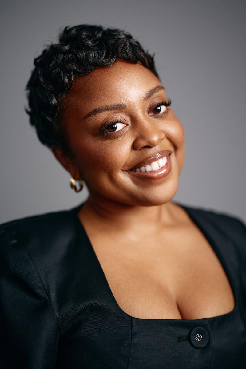 A close-up portrait of a woman with short dark hair smiling.