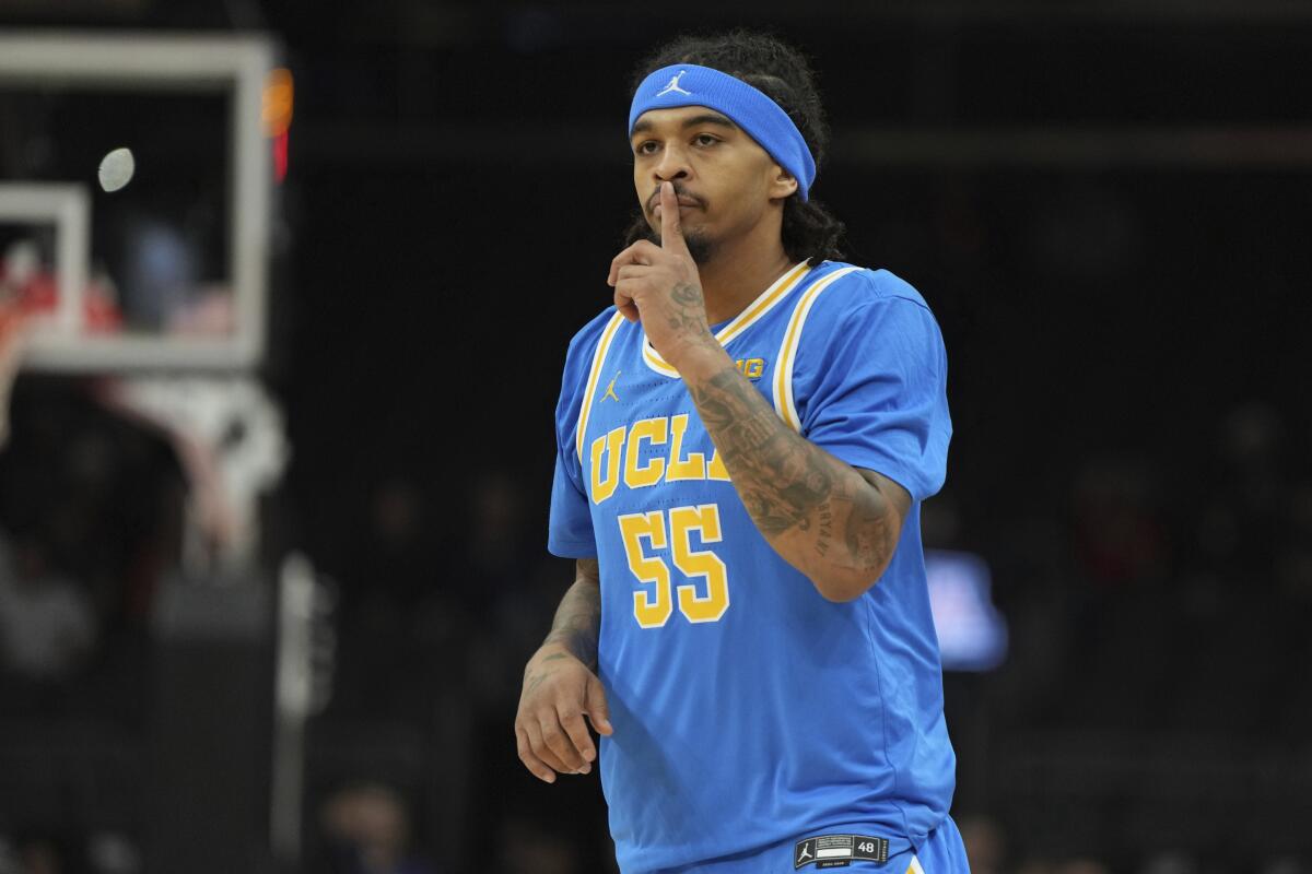 UCLA guard Skyy Clark (55) holds his fingers to lips, attempting to silence the crowd during a road game against Arizona