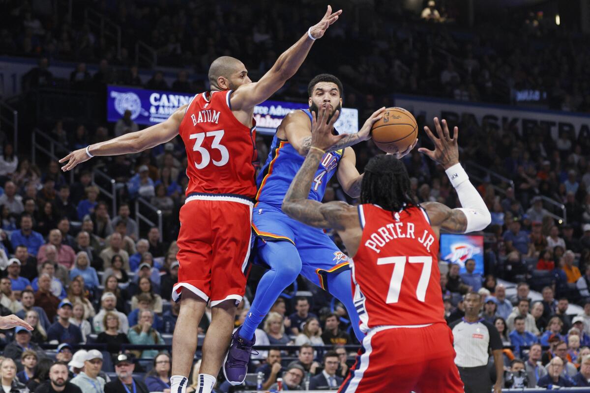 Oklahoma City Thunder forward Kenrich Williams, center, looks to pass the ball away.