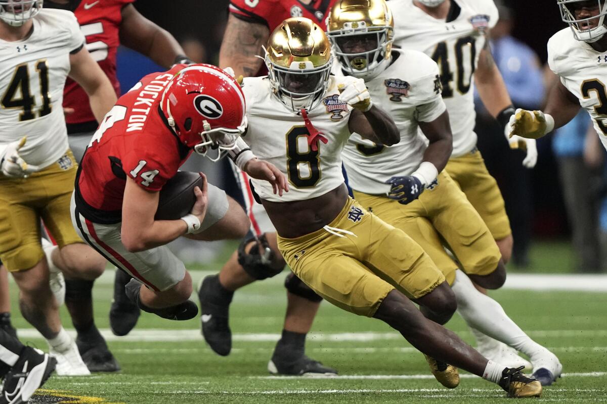 Georgia quarterback Gunner Stockton (14) is tackled by Notre Dame safety Adon Shuler.