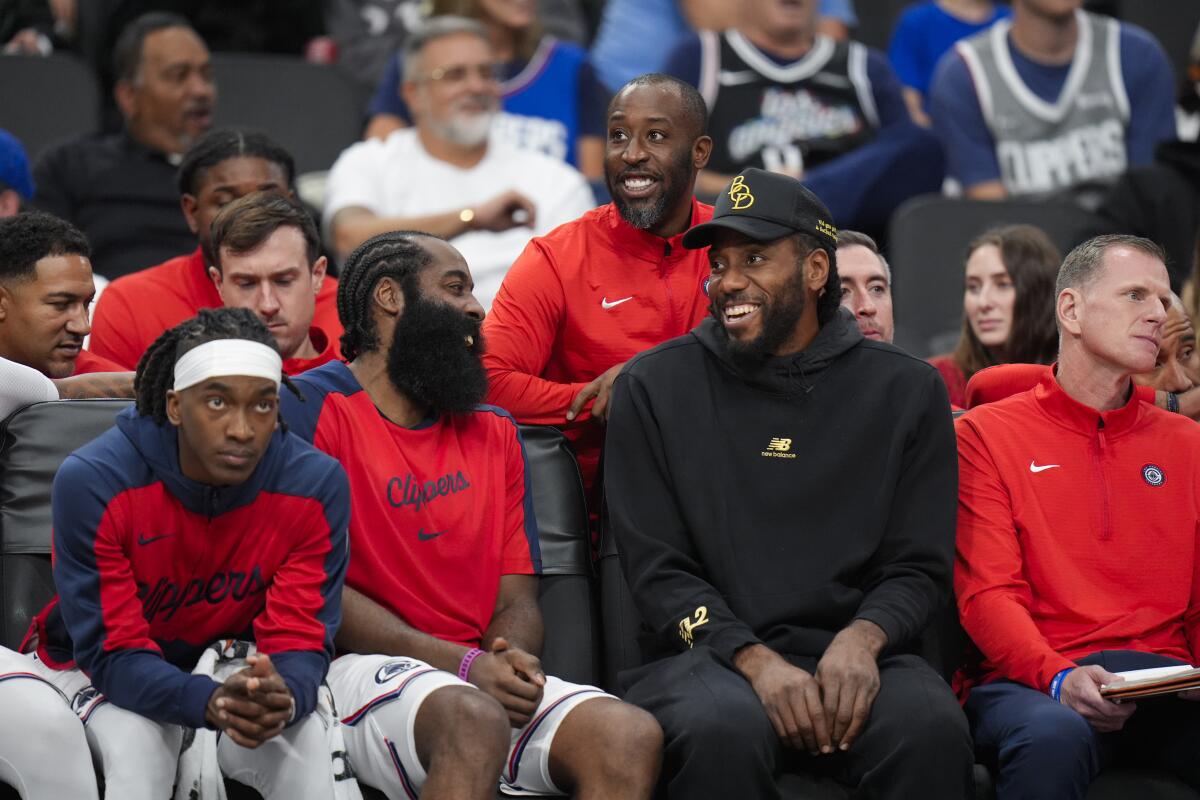 Clippers teammates James Harden, center left, and Kawhi Leonard share a laugh during a preseason game.