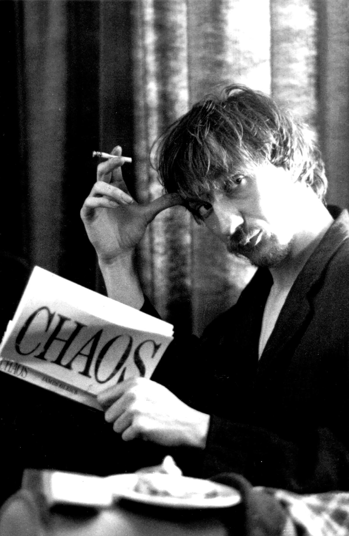 A smoking man reads the book "Chaos."