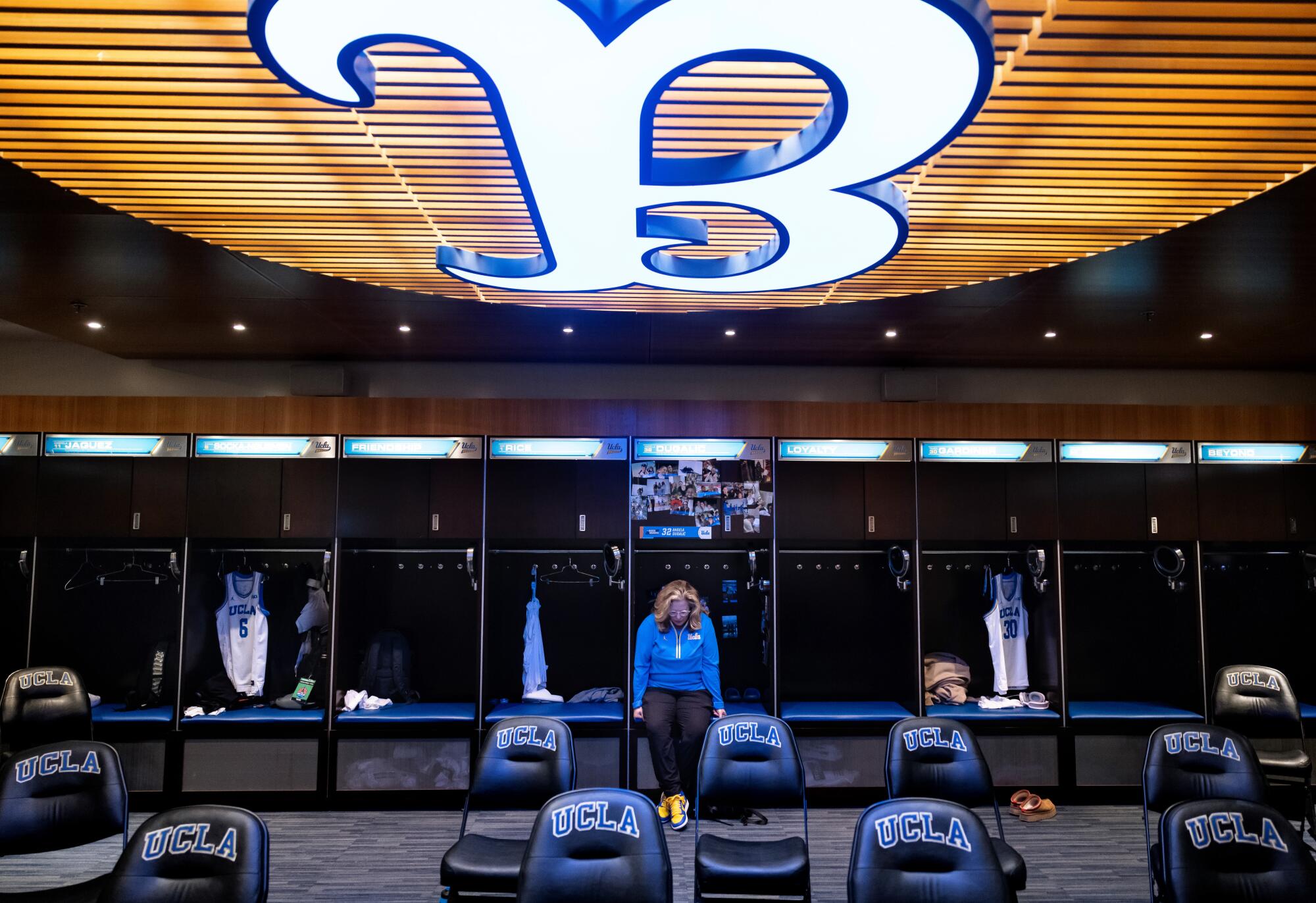 UCLA women's basketball coach Cori Close prays in the locker room by herself.