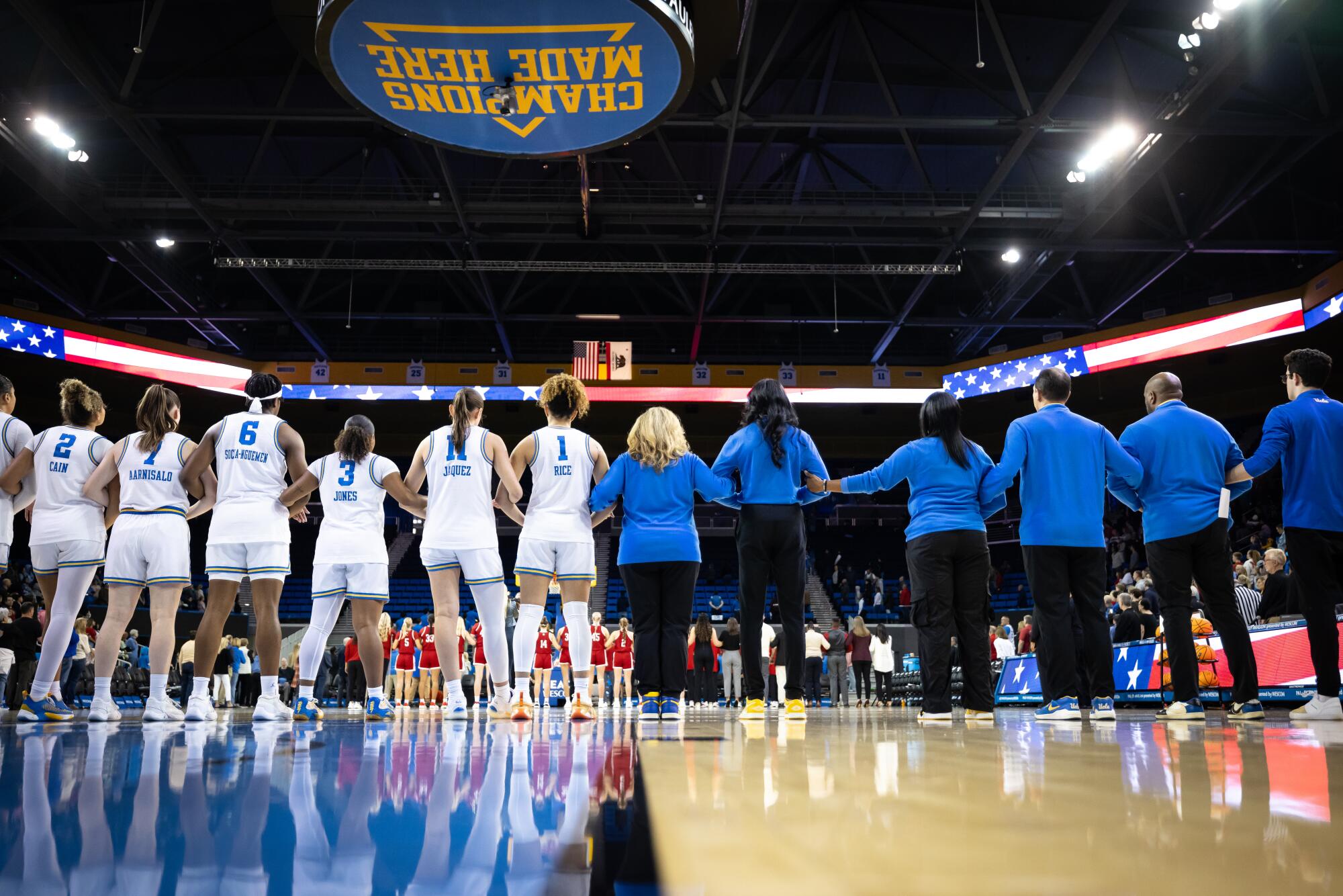 UCLA Women's Basketball Head Coach Cori Close, center, stands for the national anthem with her team.