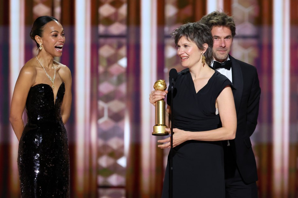 Zoe Saldana runs up on stage as Camille and Clément Ducol win Best Original Song