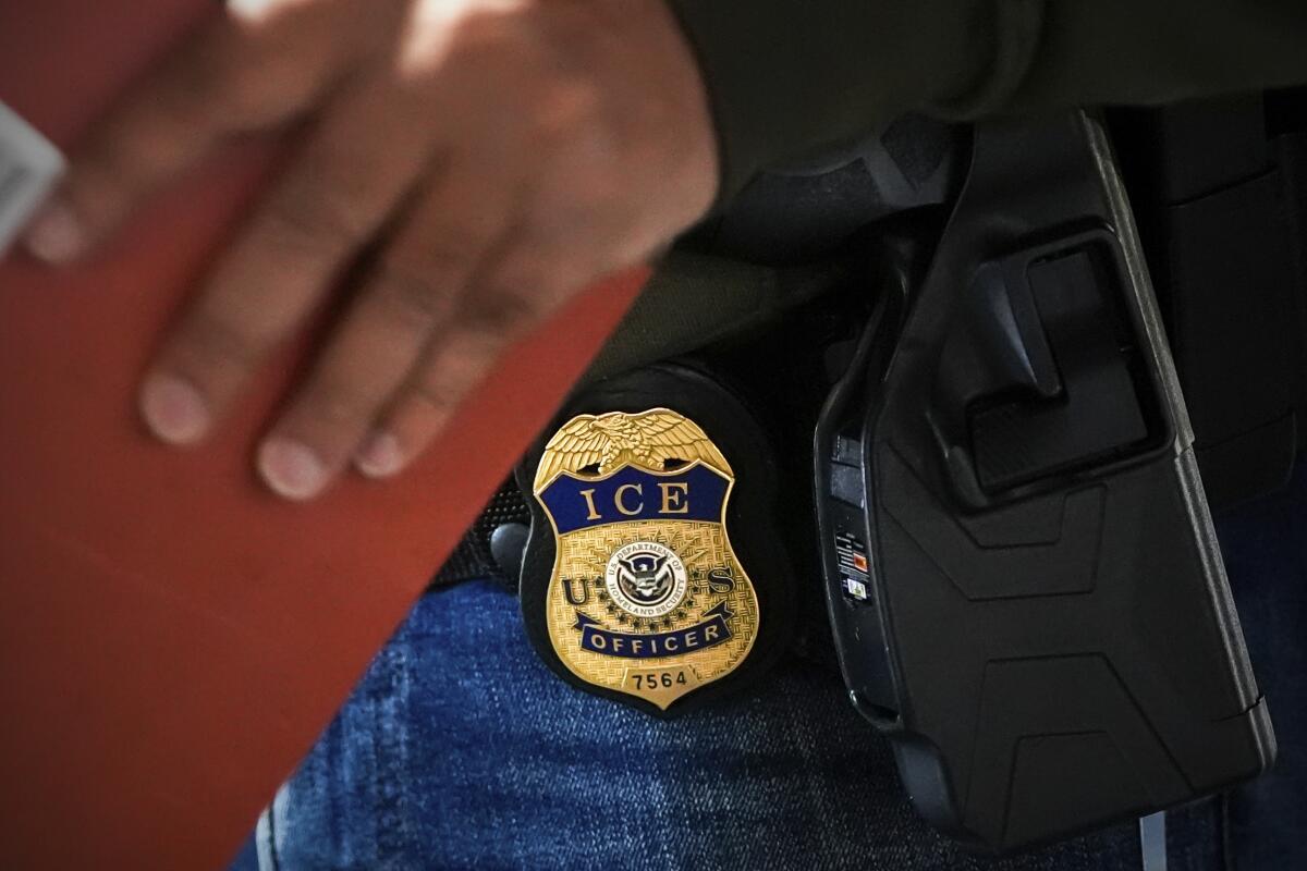 An officer wears an ICE badge on a pair of jeans. 