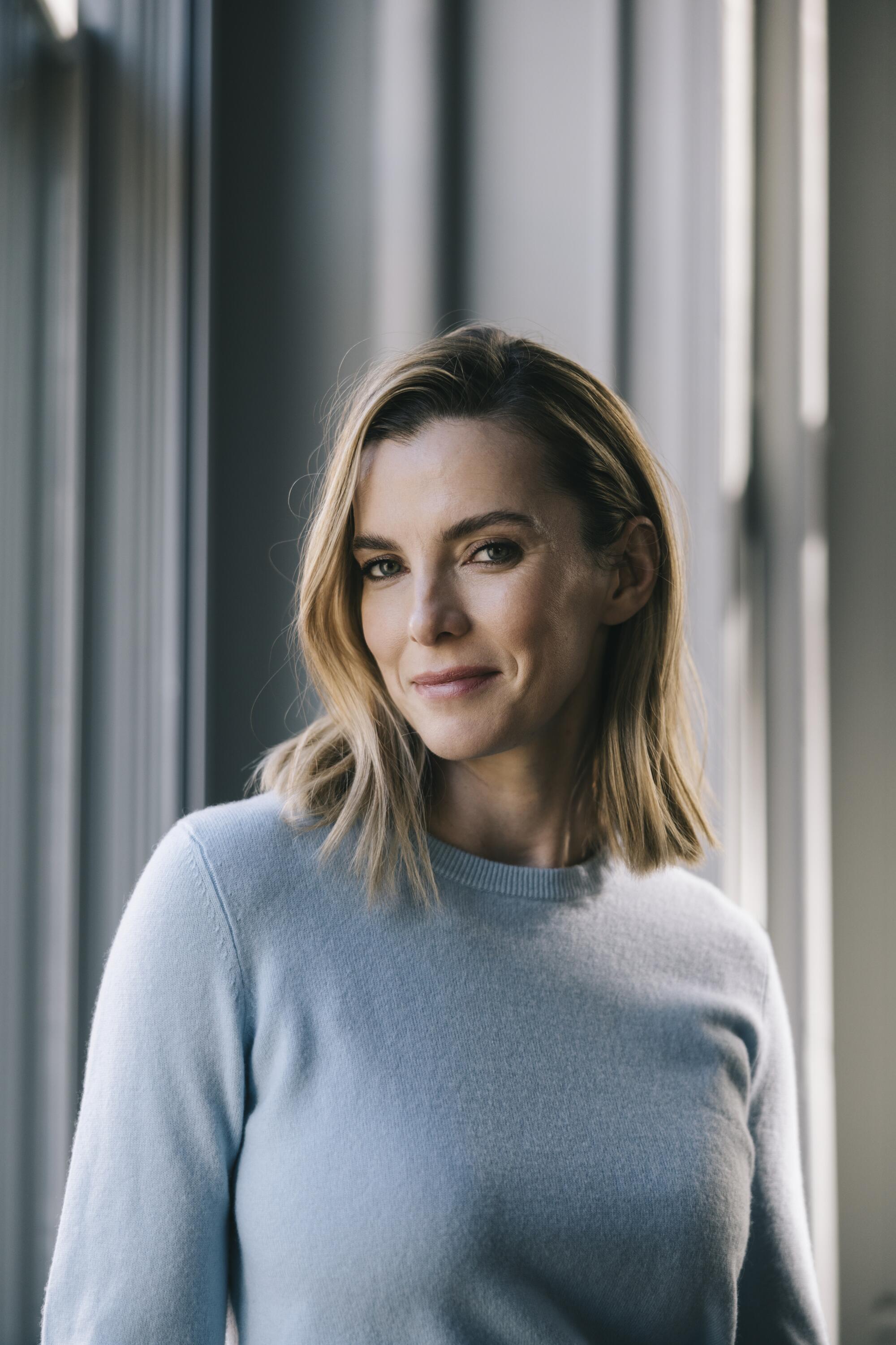 A smiling woman with shoulder length blond hair in a light blue sweater.