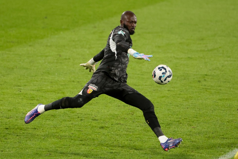 Hervé Kouakou Koffi, RC Lens goalkeeper, diving to save a soccer ball.