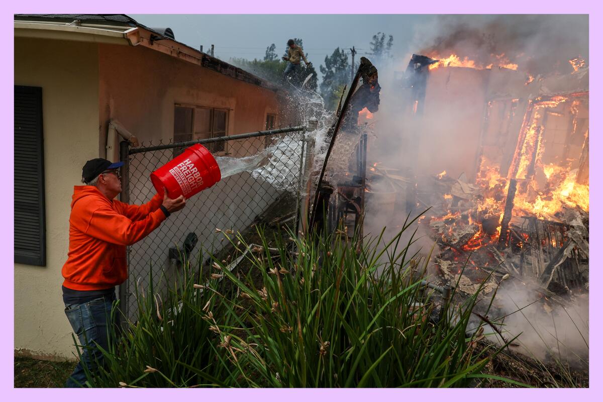 A man tosses water from a bucket onto a burning home.