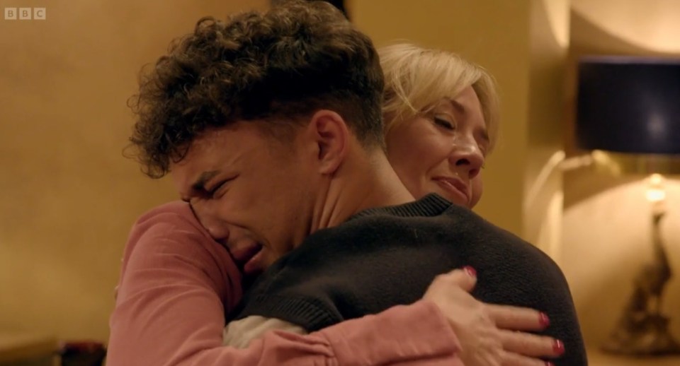 A young man crying while being hugged by a woman.