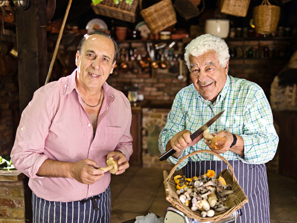 Two chefs preparing mushrooms in a kitchen.