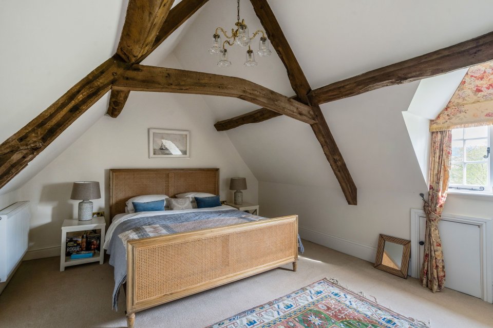 Bedroom in a manor house with exposed wooden beams.