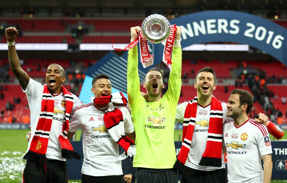 Manchester United players celebrating with the FA Cup trophy.