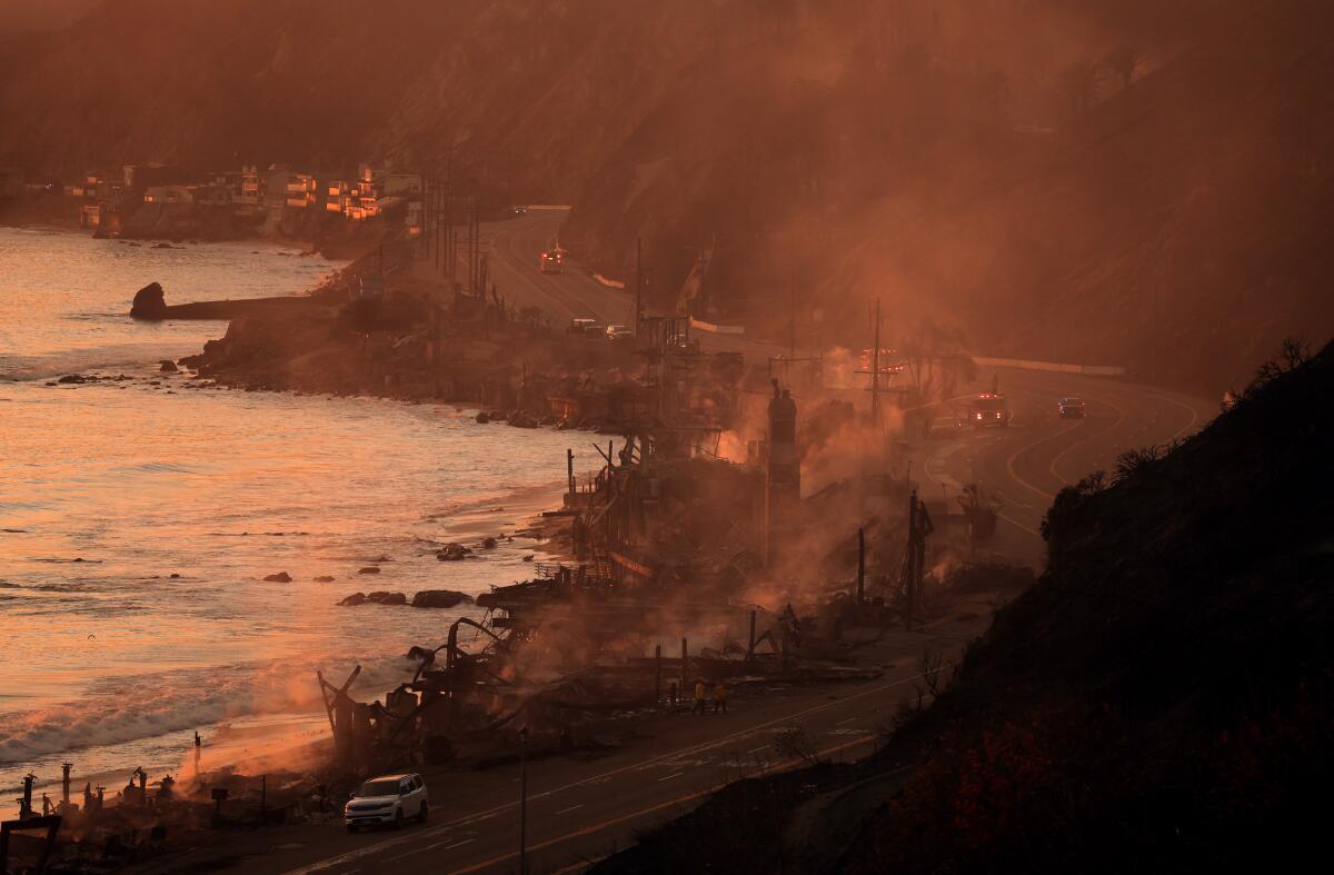 Houses smolder from the Palisades fire on Pacific Coast Highway in Malibu. 