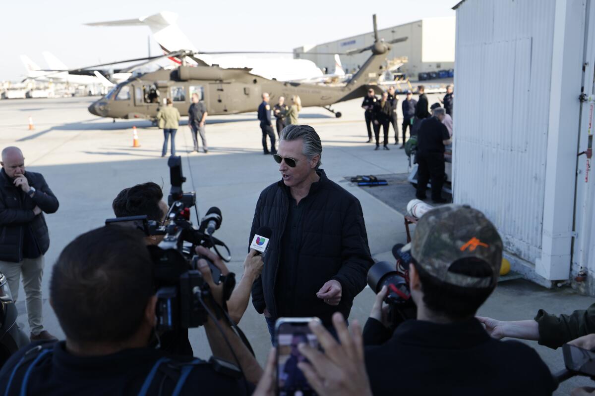 Gov. Gavin Newsom speaks with reporters at LAX.