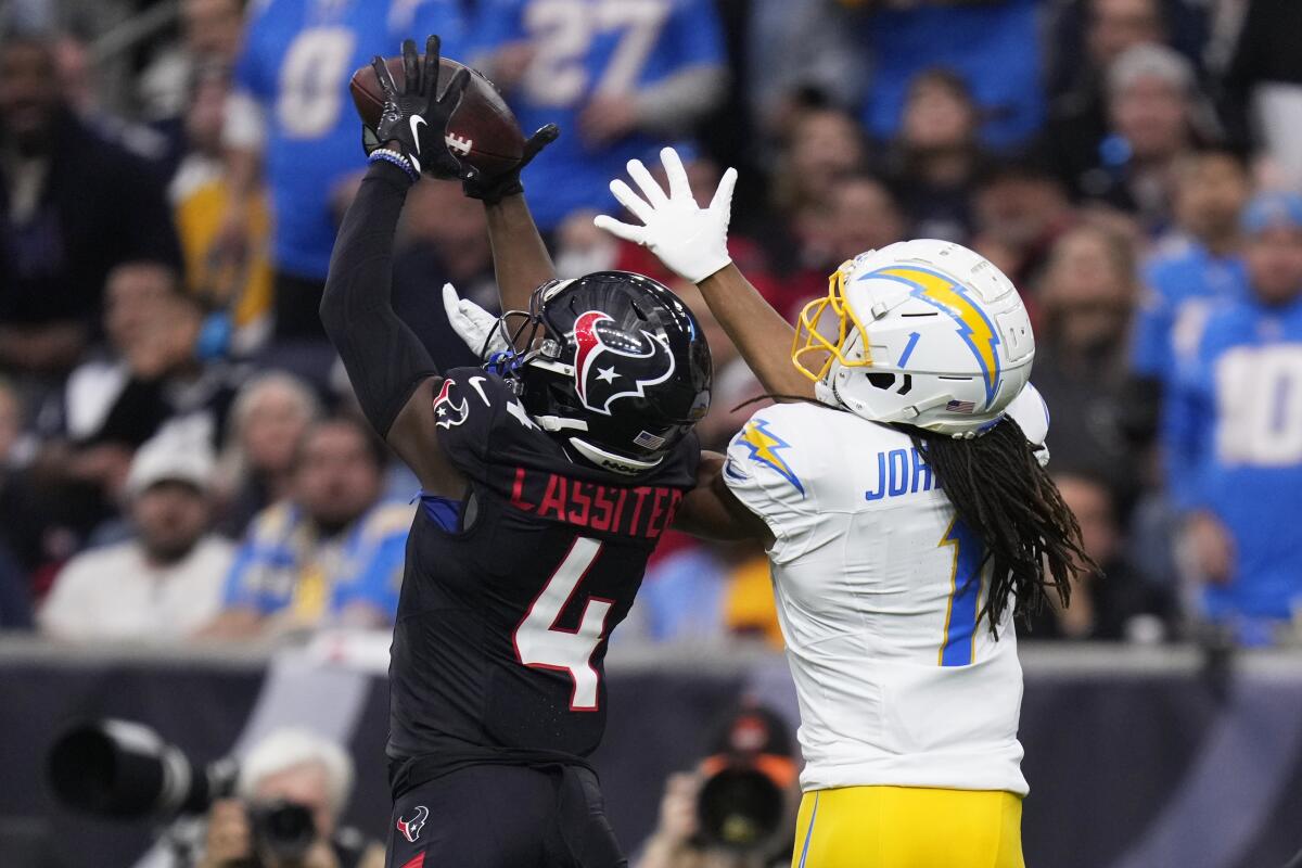 Texans cornerback Kamari Lassiter (4) intercepts a pass intended for Chargers  receiver Quentin Johnston (1).