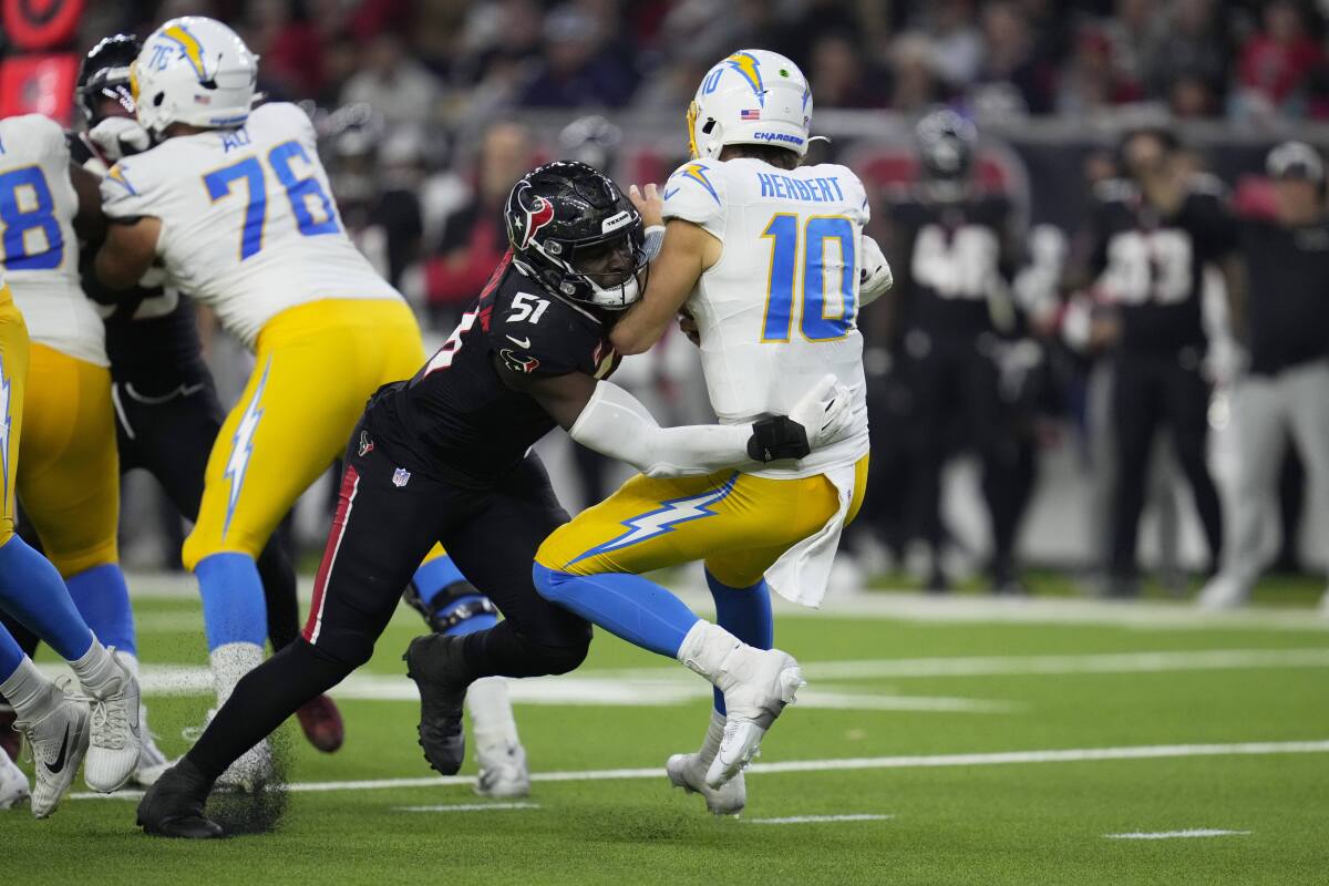 Chargers quarterback Justin Herbert (10) is sacked by the Texans' Will Anderson Jr. 