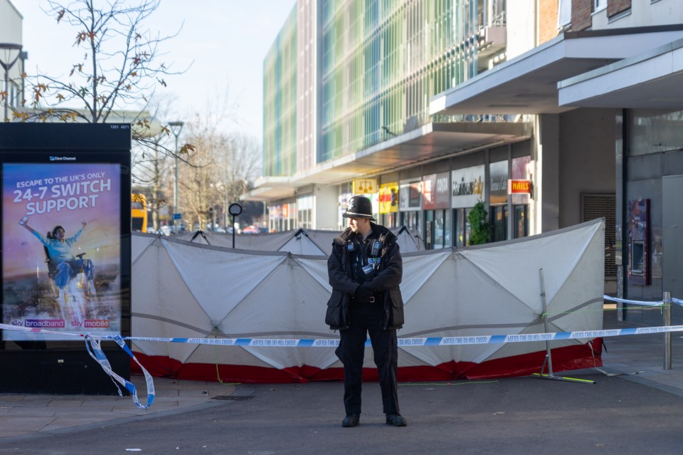 Police officer at a Bedford bus station stabbing crime scene.