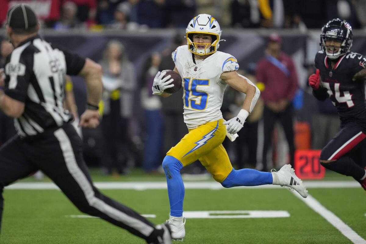 The Chargers' Ladd McConkey (15) runs to complete an 86-yard touchdown catch as the Texans' Derek Stingley Jr. (24) trails. 