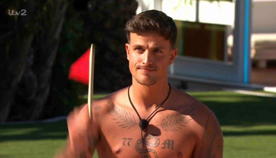 Luca Bish from ITV2 Love Island All Stars holding a red flag.